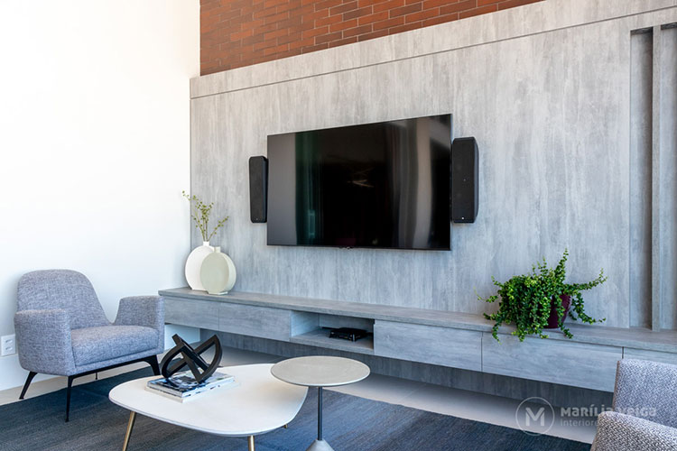home theater integrado ao terraço gourmet com a televisão sobre uma linda smartstone, ambiente claro em tons de cinza