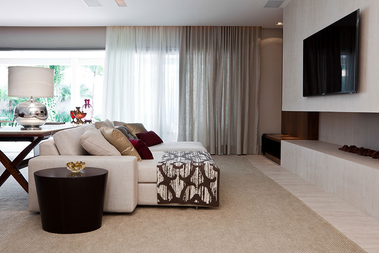 home theater integrado com sofá claro e lareira