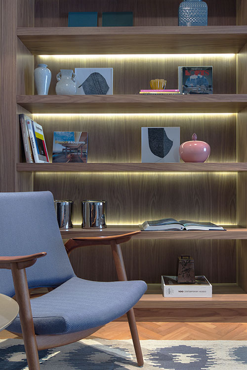 estante de marcenaria customizada com livros e itens de decoração