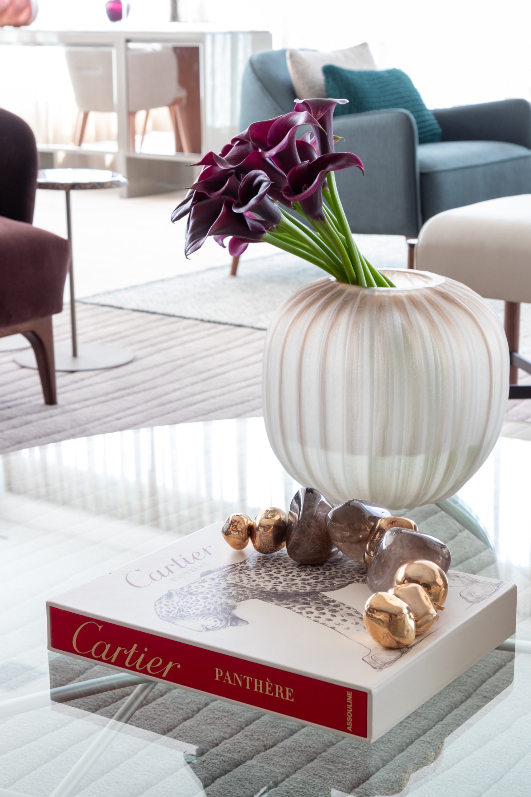 Detalhes de decoração de interiores com vaso de flores e livro sobre mesa de vidro